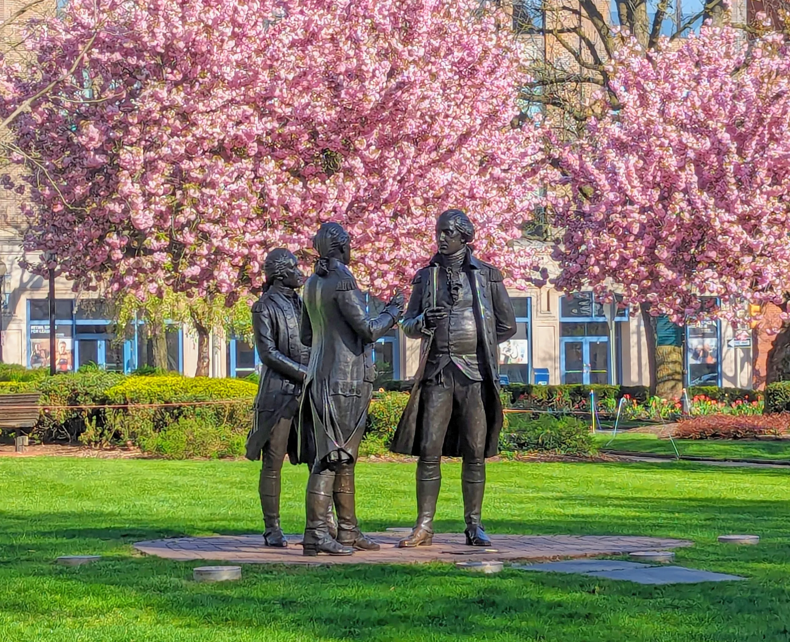Historic statues beneath pink spring blossoms on the Morristown Green in Morristown, New Jersey.