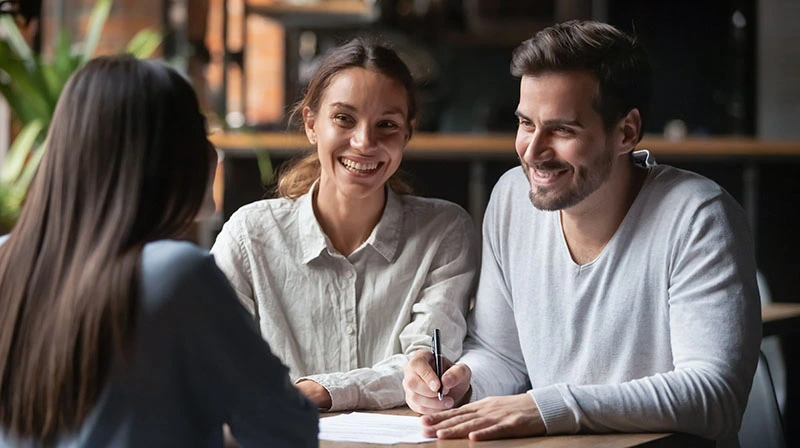 Buyers with Listing Agent signing document